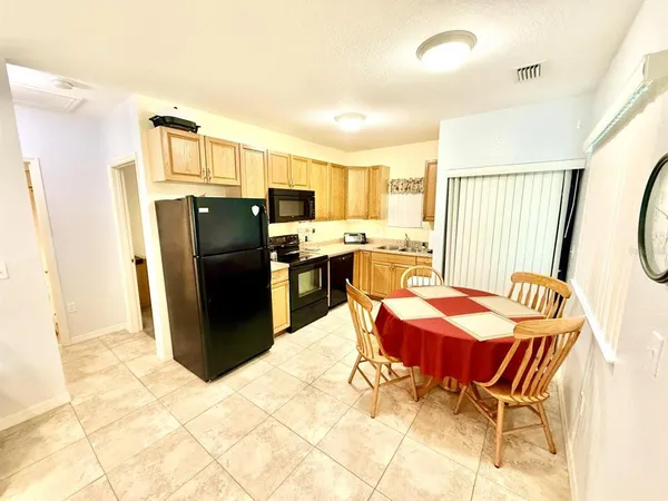 a dining room with stainless steel appliances a dining table and chairs