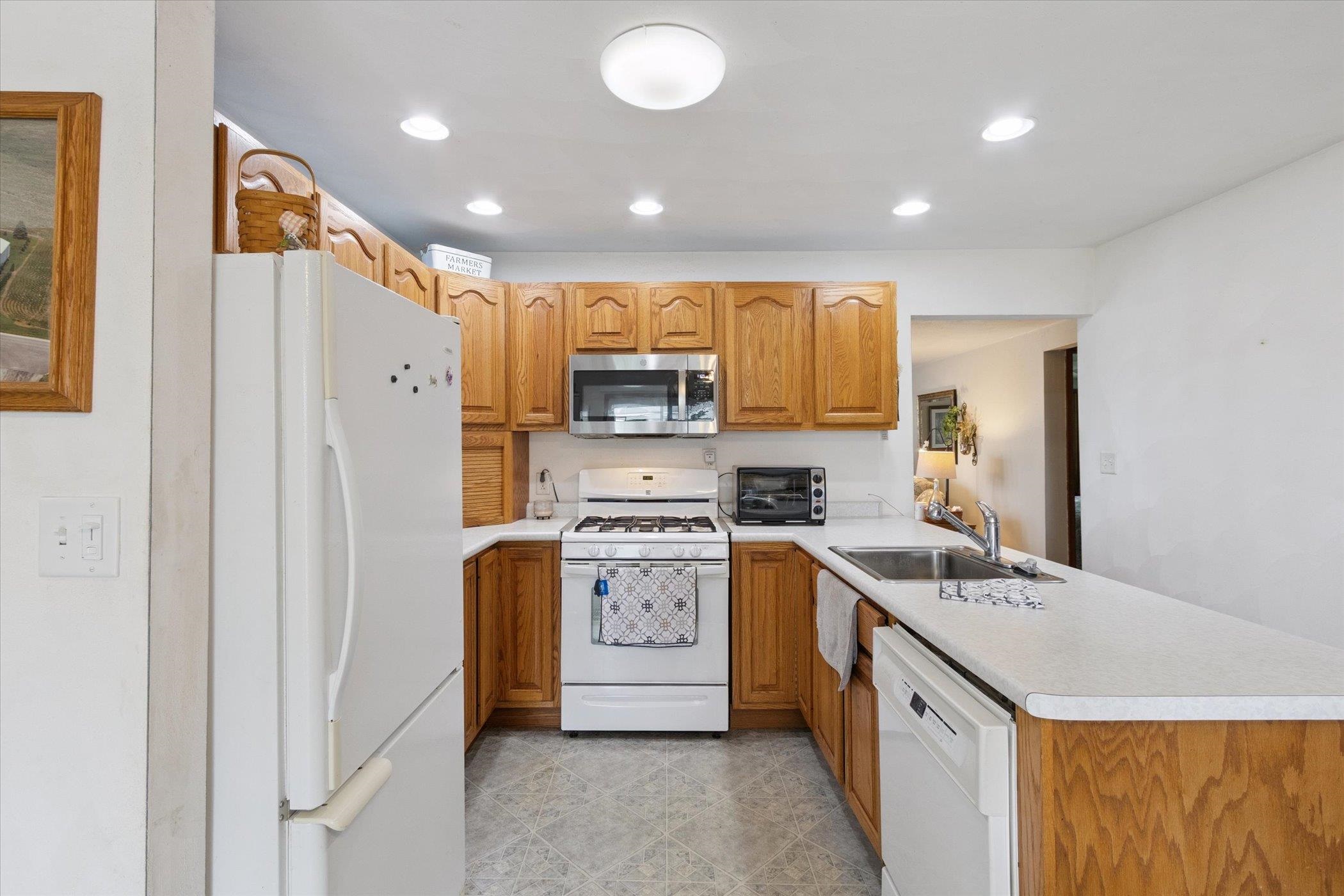 976 East Cedarville Road Freeport, IL 61032 - Photo 12 of 48 a kitchen with a sink a refrigerator a stove and a microwave