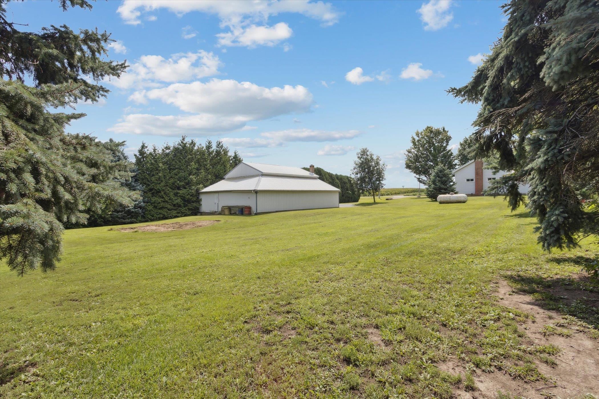 976 East Cedarville Road Freeport, IL 61032 - Photo 43 of 48 a view of a large pool with lawn chairs under an umbrella
