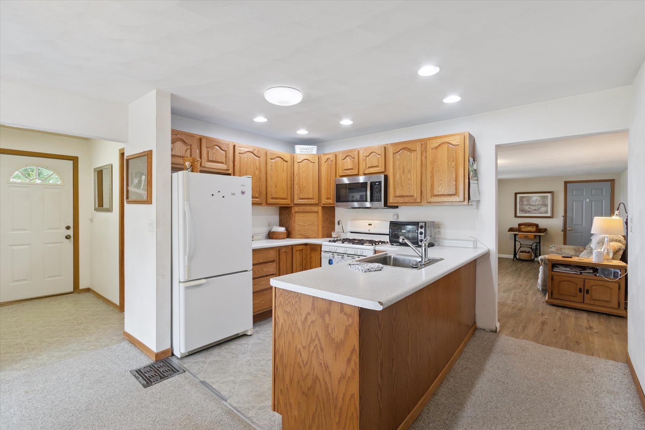 976 East Cedarville Road Freeport, IL 61032 - Photo 10 of 48 a kitchen with a refrigerator a stove top oven a sink and a counter top space