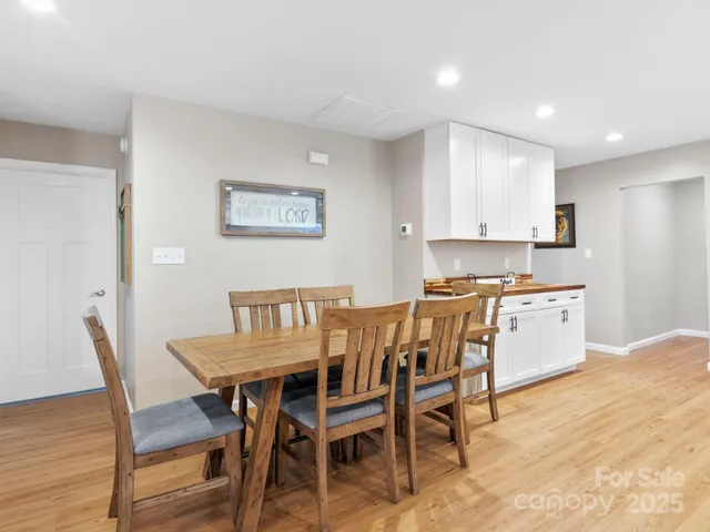 a kitchen with stainless steel appliances kitchen island granite countertop a dining table chairs and granite counter tops