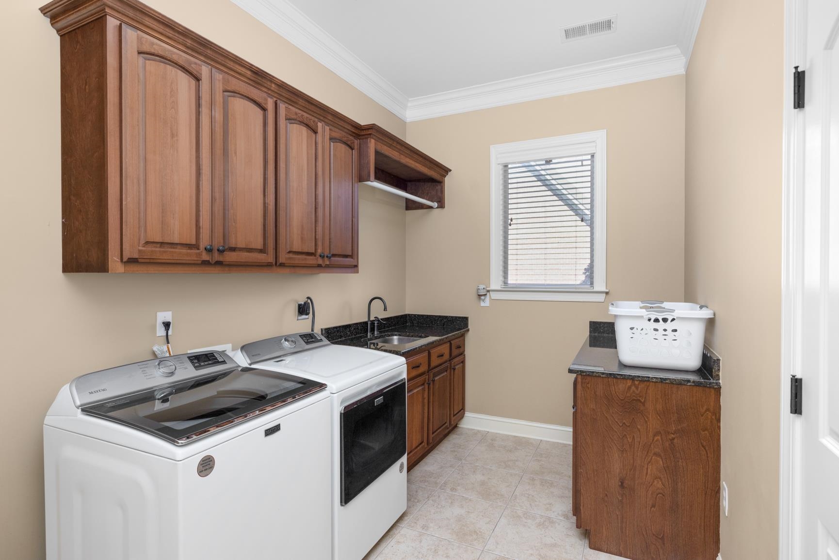 104 Eagle Trace Road Covington, TN 38019 - Photo 30 of 40 Laundry room featuring cabinet space, crown molding, washing machine and clothes dryer, and light tile patterned flooring