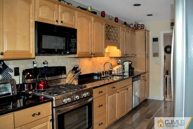 18 Chelsea Road Old Bridge, NJ 08857 - Photo 8 of 25 a kitchen with stainless steel appliances a stove a microwave a refrigerator and cabinets