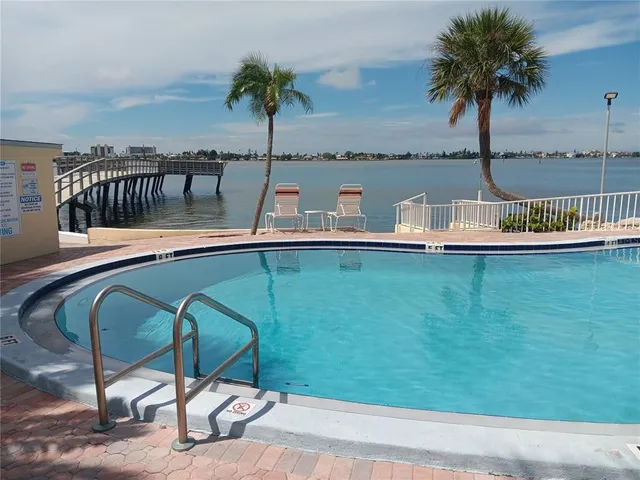 a view of swimming pool with outdoor seating and plants