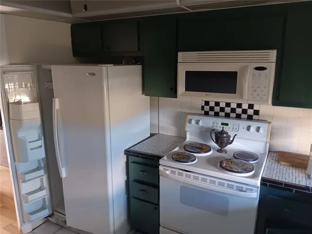 a kitchen with stainless steel appliances a refrigerator and a stove top oven
