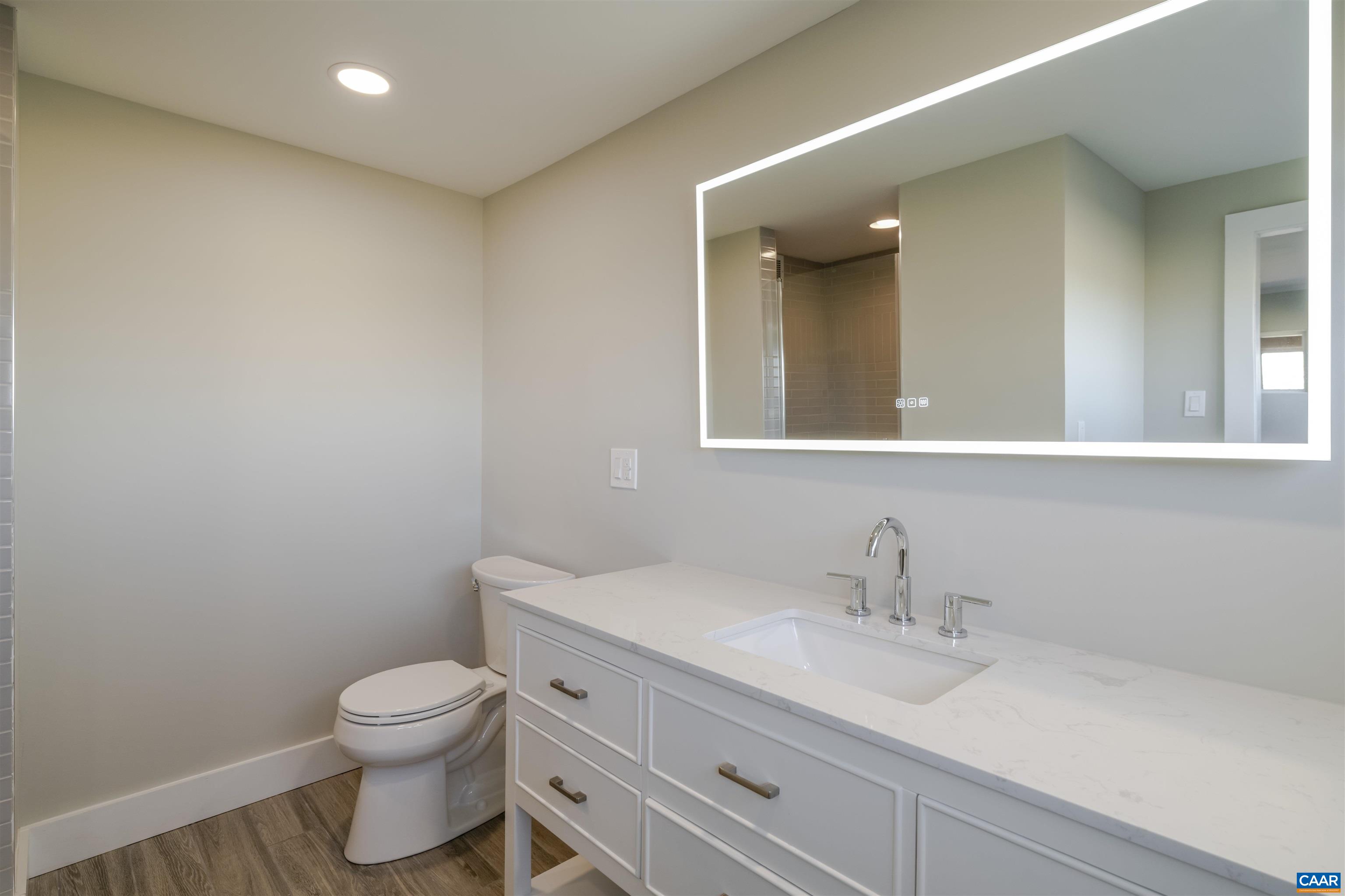 12413 Chicken Mountain Road Orange, VA 22960 - Photo 21 of 36 a bathroom with a toilet a sink a mirror and vanity