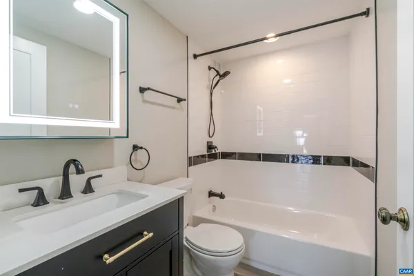 a bathroom with a sink mirror toilet and bathtub
