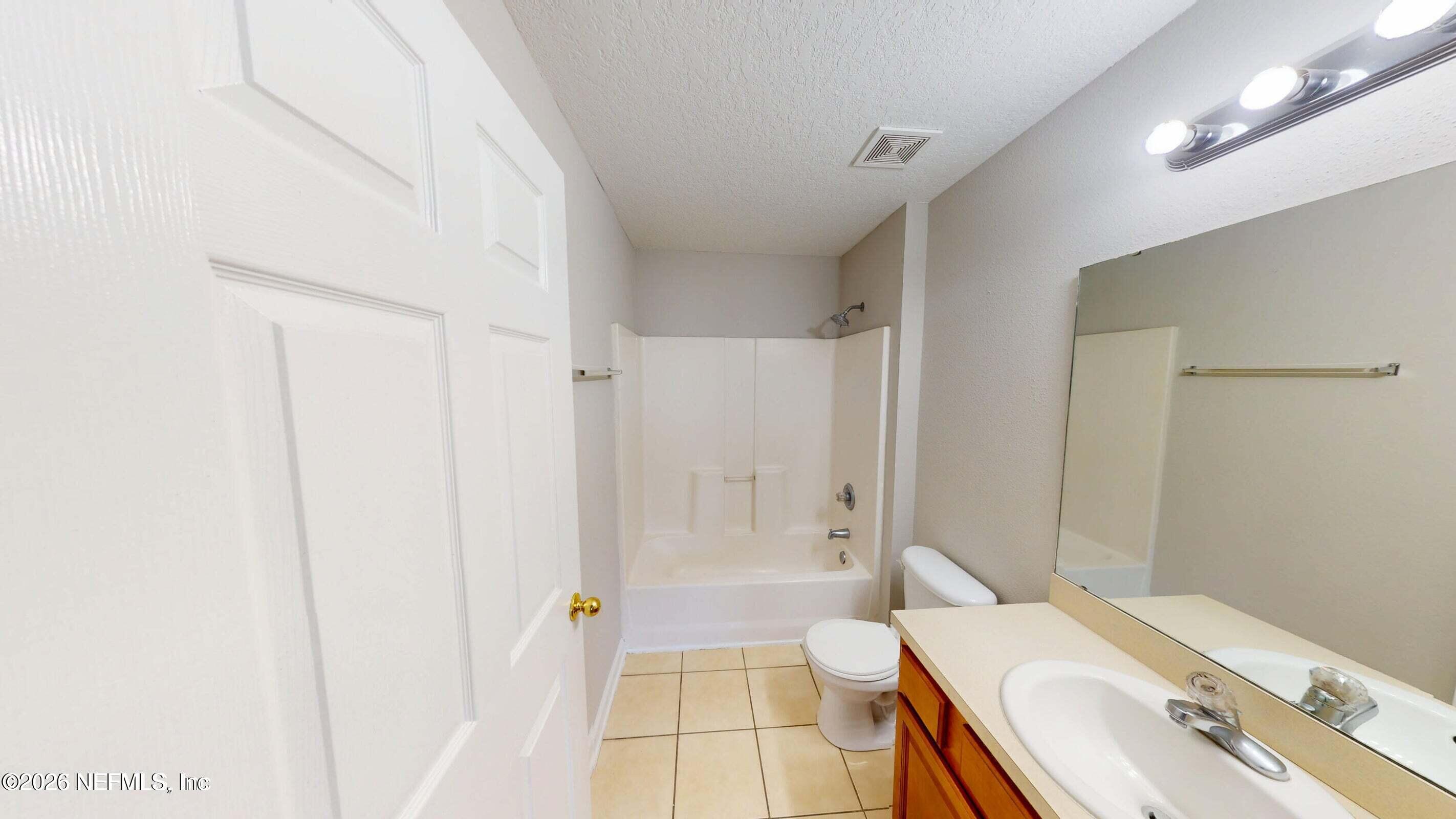 7920 Merrill Road, Unit 1509 Jacksonville, FL 32277 - Photo 7 of 11 a bathroom with a sink a toilet and shower
