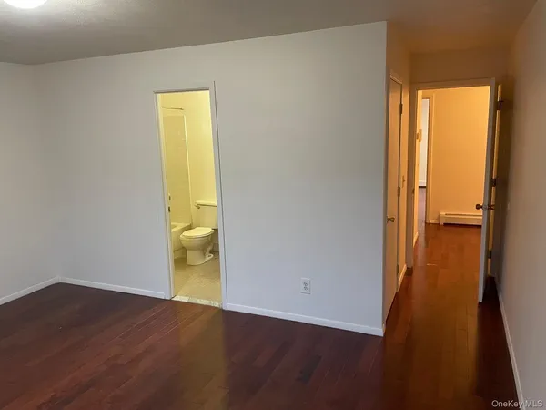 a view of a room with wooden floor and a window