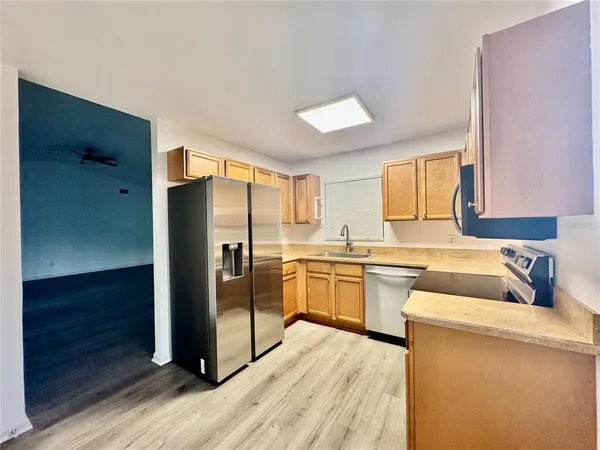 a kitchen with a refrigerator sink and cabinets