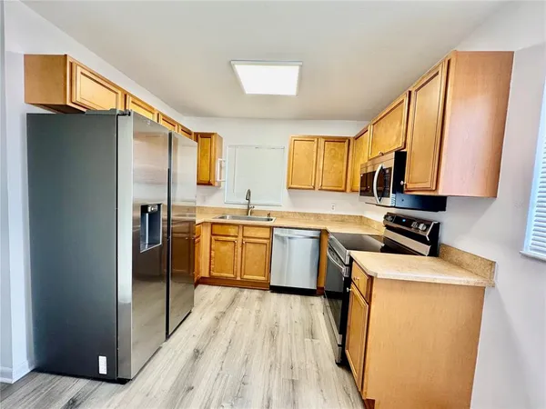 a kitchen with a sink a counter top space stainless steel appliances and cabinets