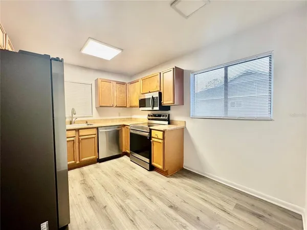 a kitchen with a refrigerator stove top oven and sink