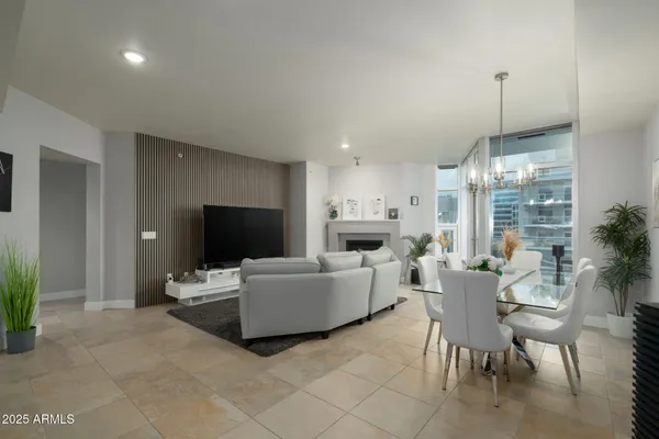 a kitchen with kitchen island granite countertop a sink a stove a refrigerator cabinets and chairs