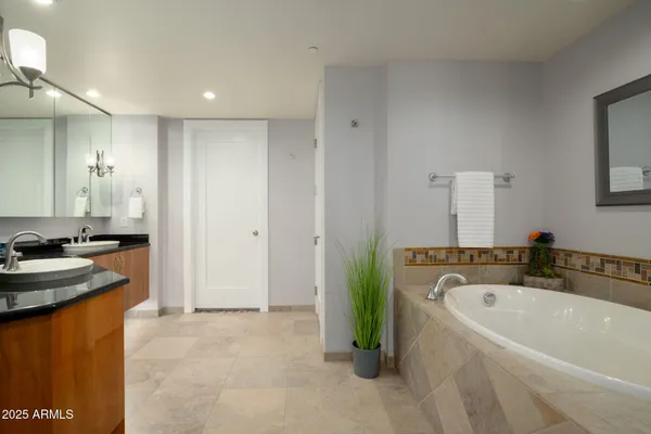 a spacious bedroom with a bed and a flat screen tv