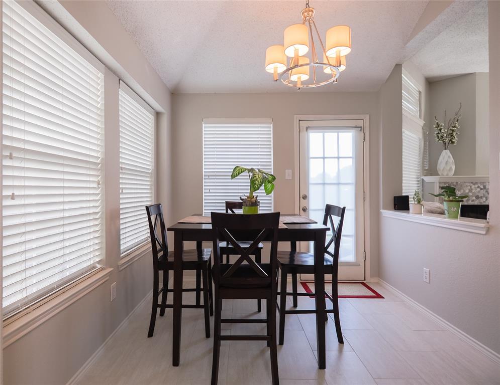 18532 Shadow Ridge Drive Dallas, TX 75287 - Photo 6 of 12 a view of a dining room with furniture a chandelier and a window