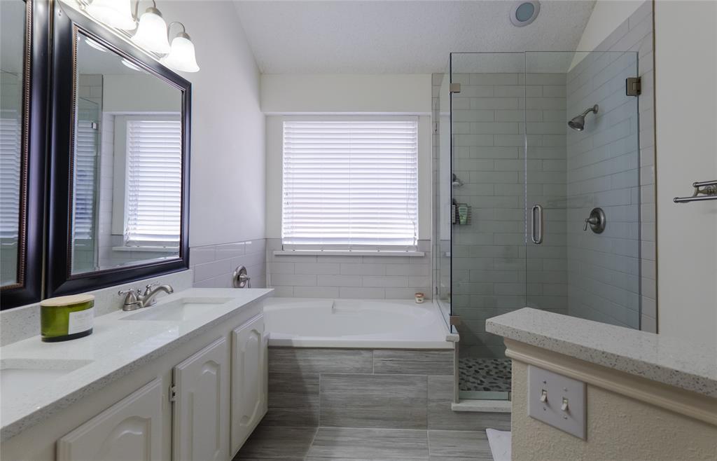 18532 Shadow Ridge Drive Dallas, TX 75287 - Photo 7 of 12 a bathroom with a granite countertop sink a toilet a mirror and shower
