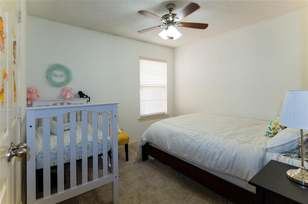 18532 Shadow Ridge Drive Dallas, TX 75287 - Photo 10 of 12 a bedroom with a bed and a chandelier