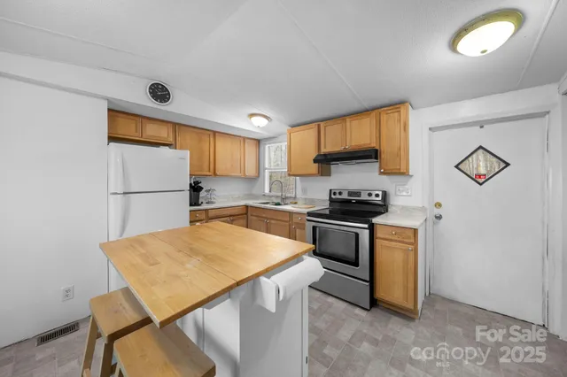 a kitchen with a refrigerator and a stove top oven