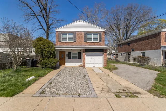a front view of a house with a yard and trees