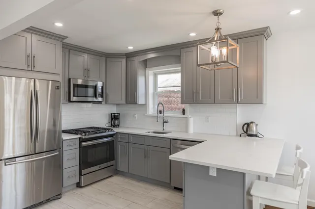 a kitchen that has a sink stainless steel appliances and cabinets