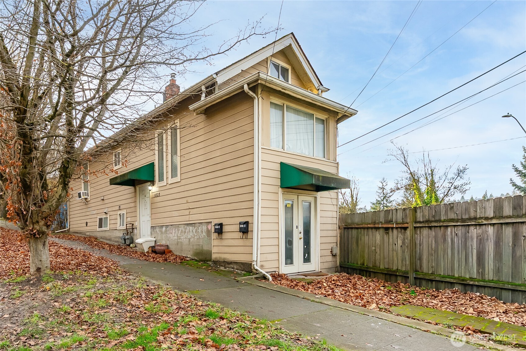 3823 Delridge Way Southwest Seattle, WA 98106 - Photo 1 of 18 a view of a house with wooden fence next to a road