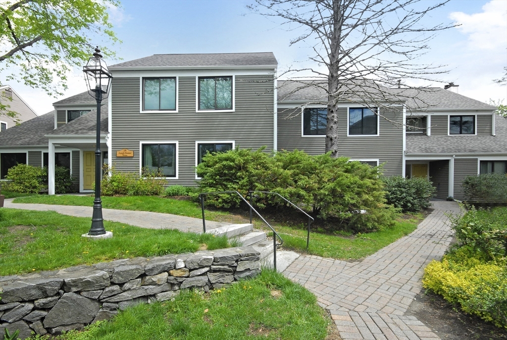 a front view of a house with a yard and potted plants