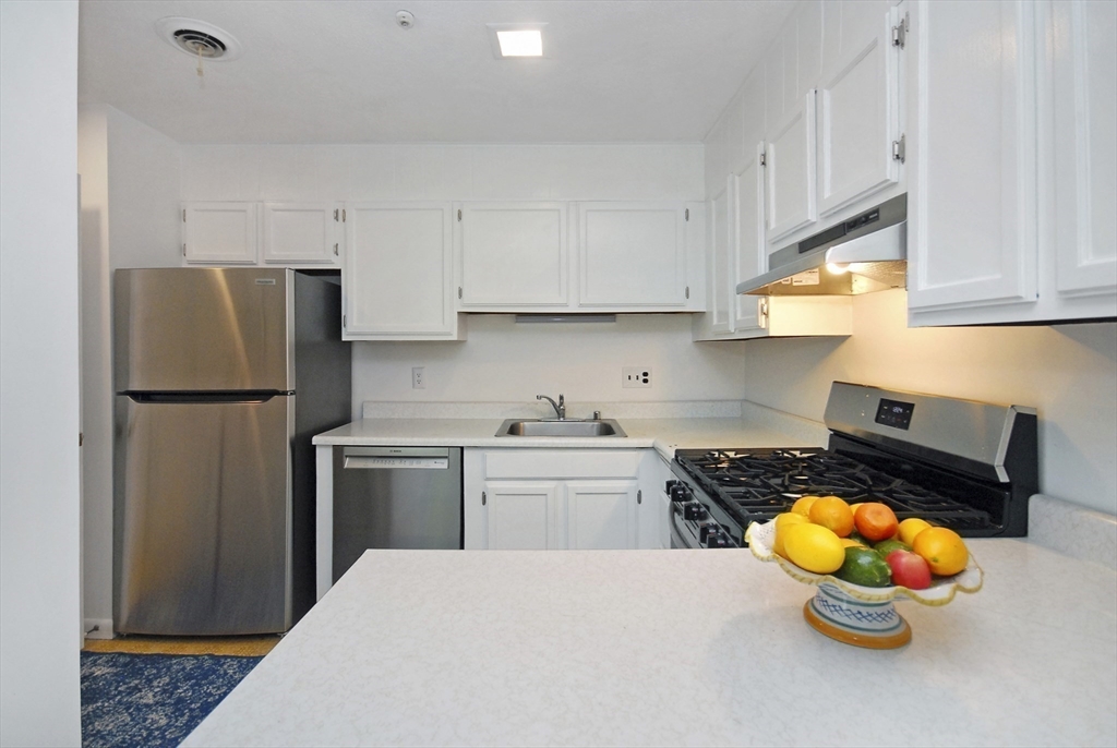 18 Concord Greene, Unit 6 Concord, MA 01742 - Photo 11 of 24 a kitchen with stainless steel appliances granite countertop a stove a refrigerator and a sink