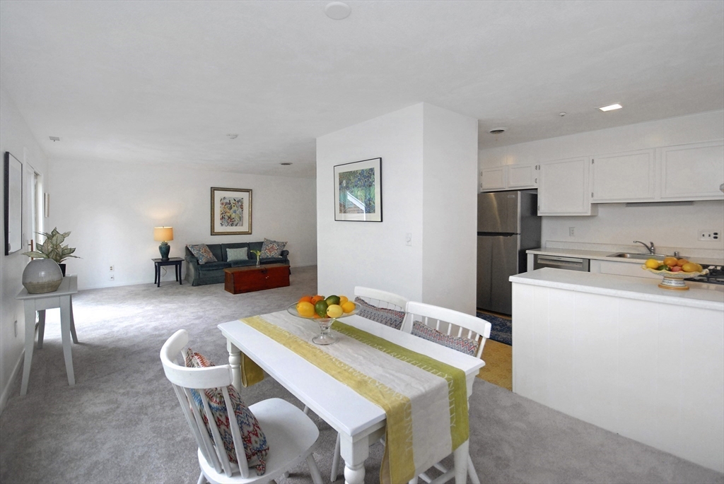 18 Concord Greene, Unit 6 Concord, MA 01742 - Photo 8 of 24 a dining room with furniture and a chandelier