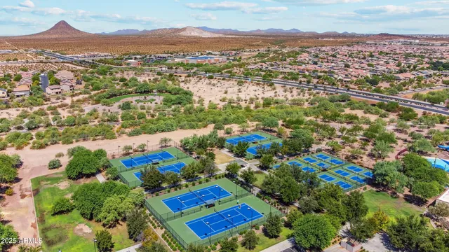 an aerial view of residential houses with outdoor space and trees