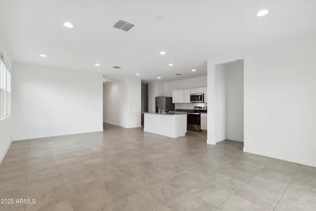 a view of kitchen with kitchen island and stainless steel appliances