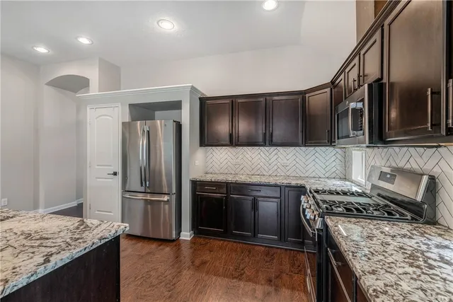 a kitchen with granite countertop stainless steel appliances and wooden cabinets