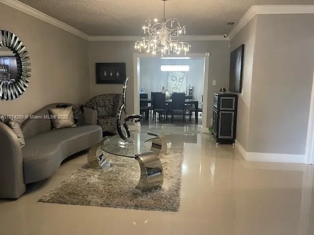 a living room with fireplace furniture and a chandelier