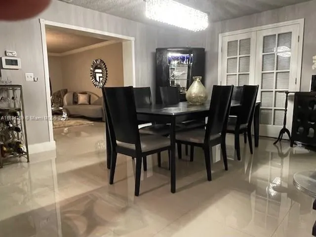 a kitchen with stainless steel appliances kitchen island granite countertop a refrigerator a stove a sink a dining table and chairs