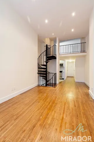 a view of a room with wooden floor and stairs