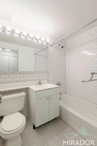a bathroom with a toilet a sink a mirror and bathtub