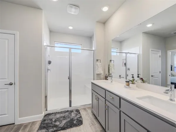 a spacious bathroom with a sink a mirror and a shower