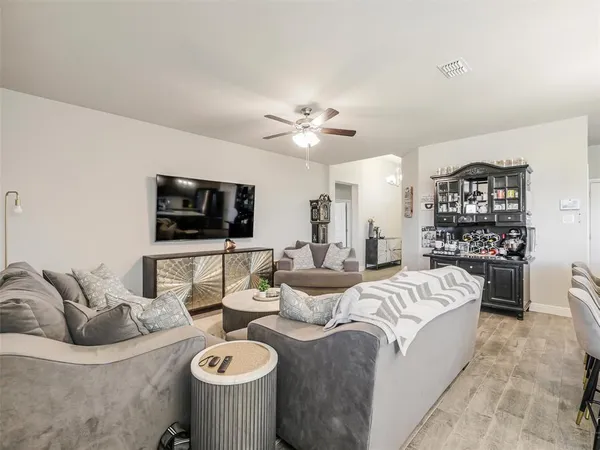 a living room with furniture a flat screen tv and kitchen view
