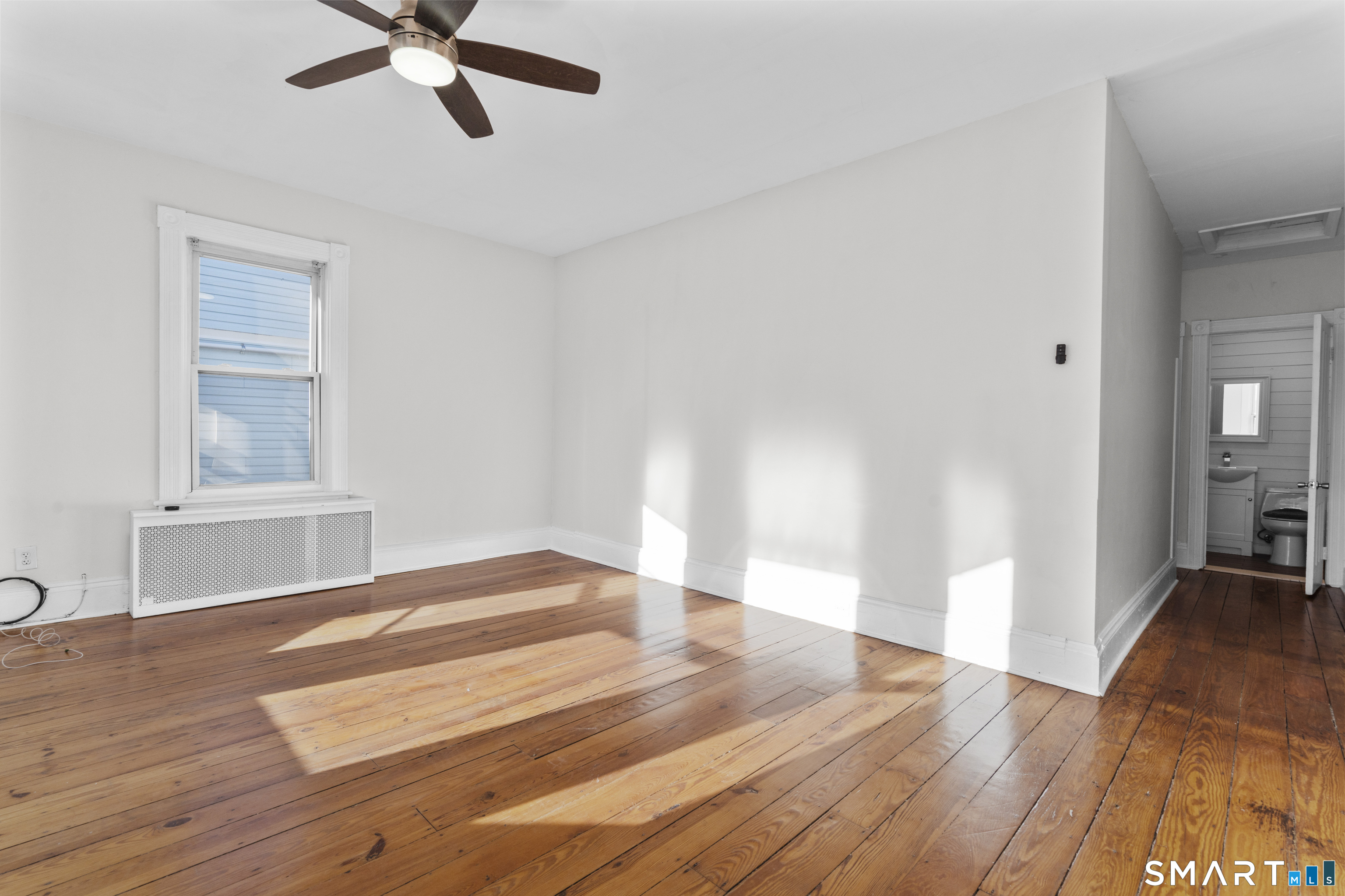 394 Gregory Street, Unit 1 Bridgeport, CT 06604 - Photo 13 of 23 a view of an empty room with wooden floor and a window