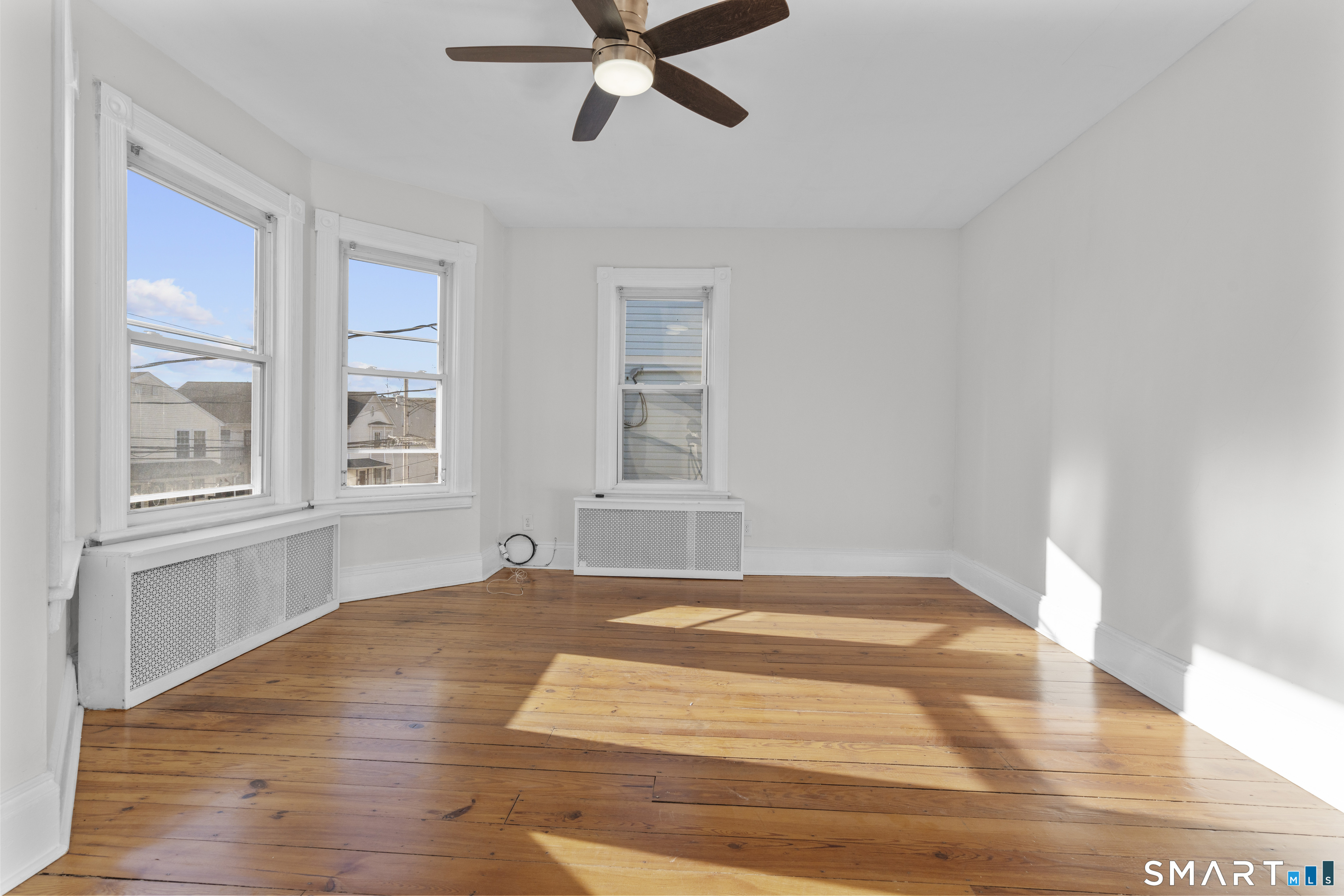 394 Gregory Street, Unit 1 Bridgeport, CT 06604 - Photo 14 of 23 a view of an empty room with a window and wooden floor