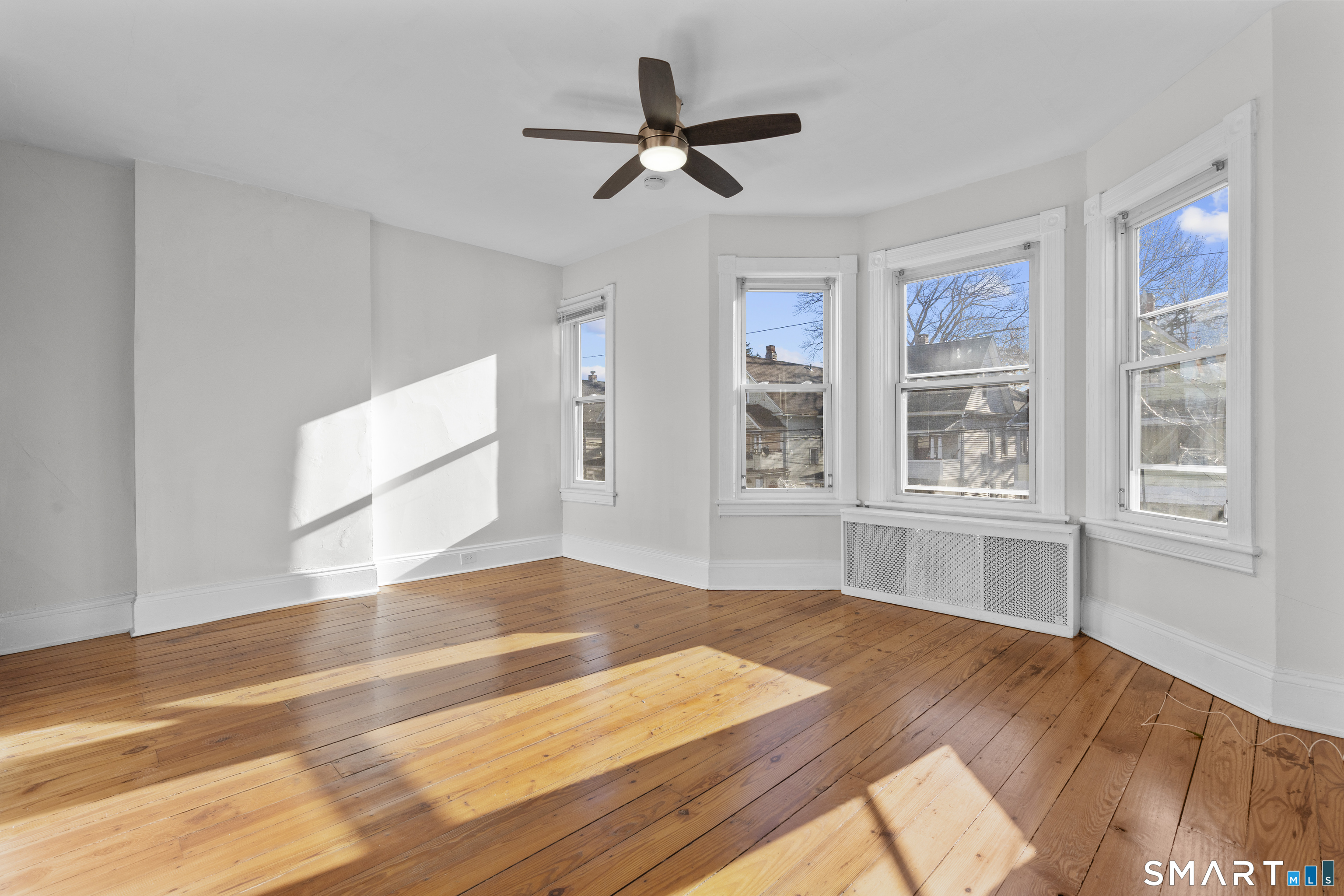 394 Gregory Street, Unit 1 Bridgeport, CT 06604 - Photo 15 of 23 a view of empty room with wooden floor and fan