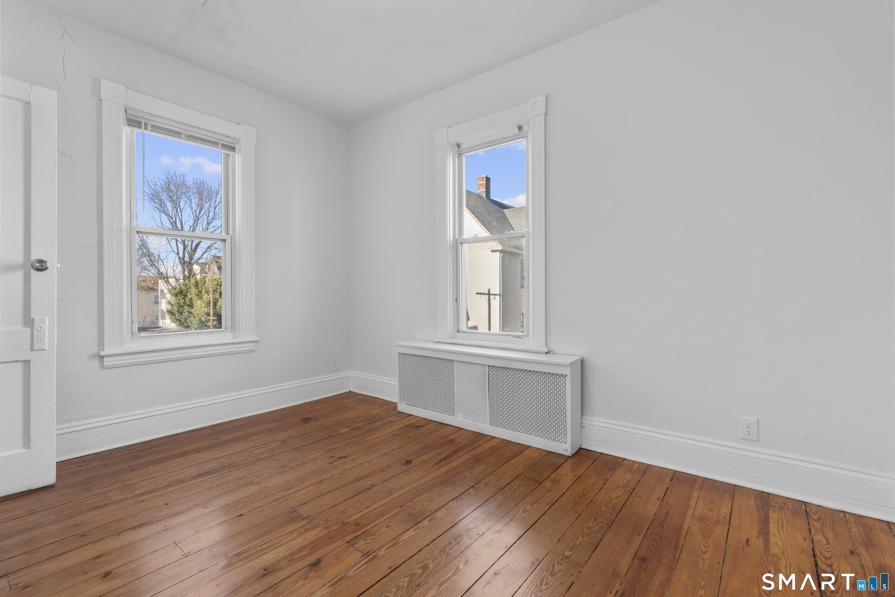 394 Gregory Street, Unit 1 Bridgeport, CT 06604 - Photo 22 of 23 an empty room with wooden floor and windows