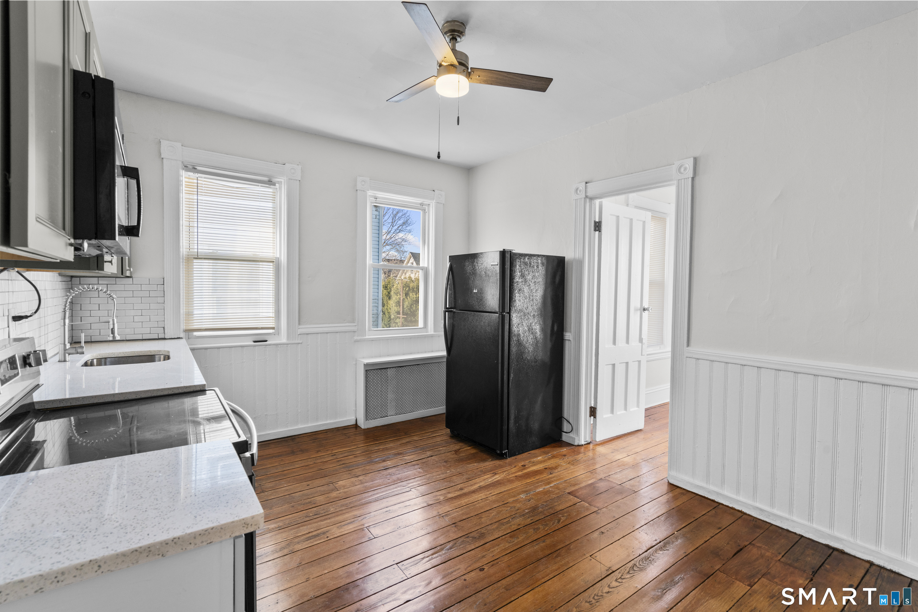 394 Gregory Street, Unit 1 Bridgeport, CT 06604 - Photo 3 of 23 a kitchen with stainless steel appliances granite countertop a refrigerator a sink and dishwasher with wooden floor