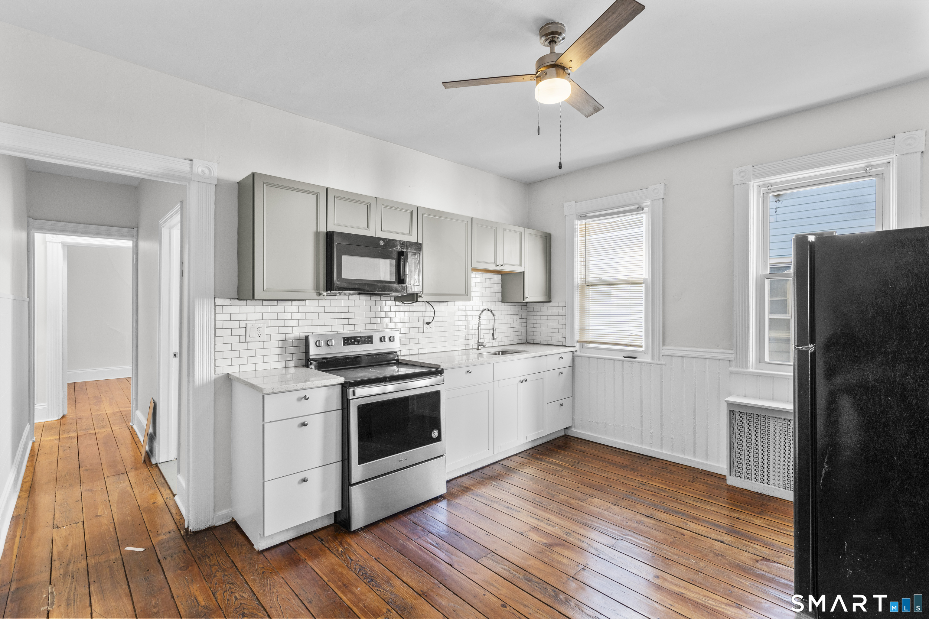 394 Gregory Street, Unit 1 Bridgeport, CT 06604 - Photo 5 of 23 a kitchen with stainless steel appliances a stove a sink dishwasher a refrigerator white cabinets and wooden floor