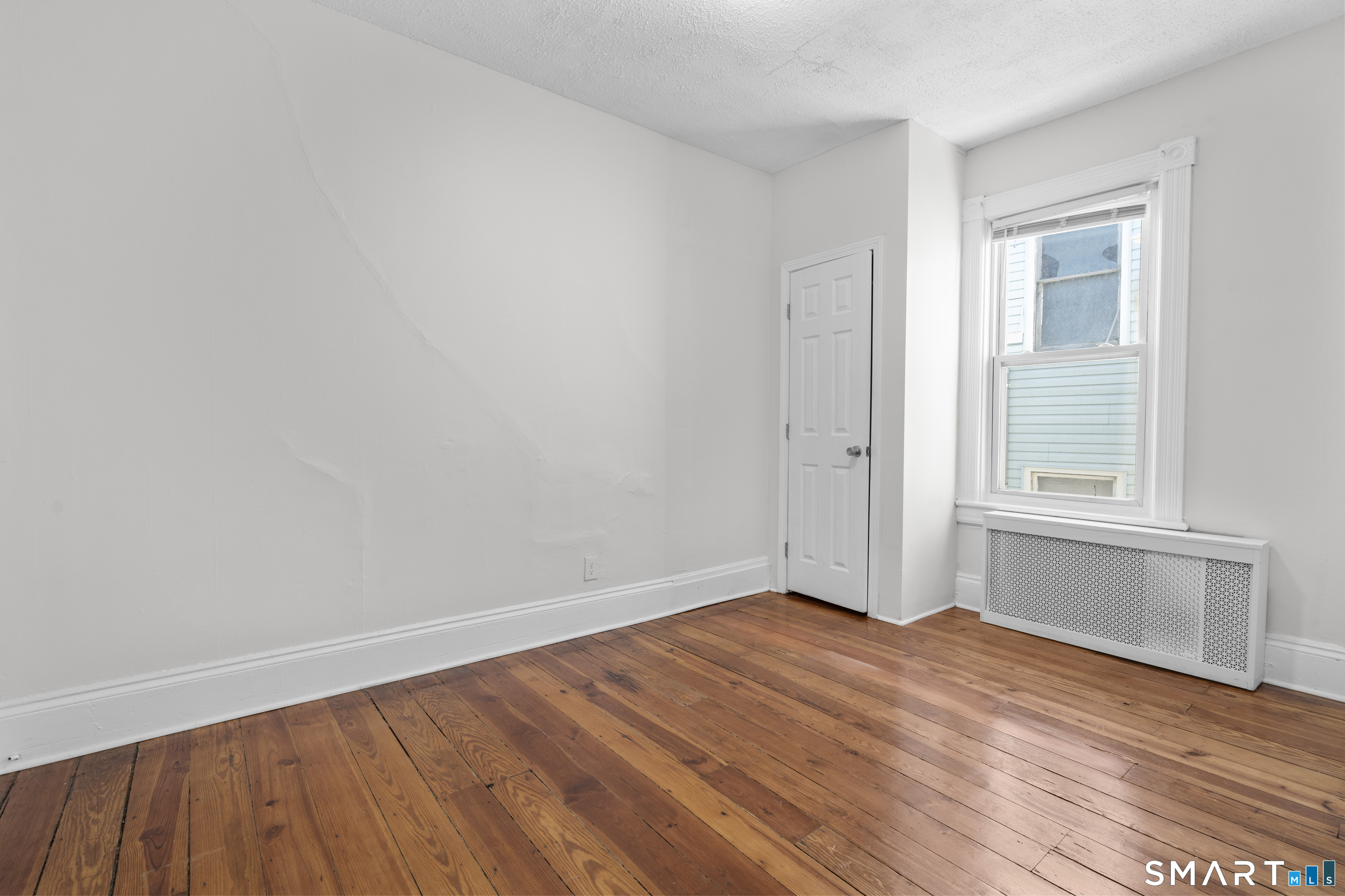 394 Gregory Street, Unit 1 Bridgeport, CT 06604 - Photo 9 of 23 an empty room with wooden floor and windows