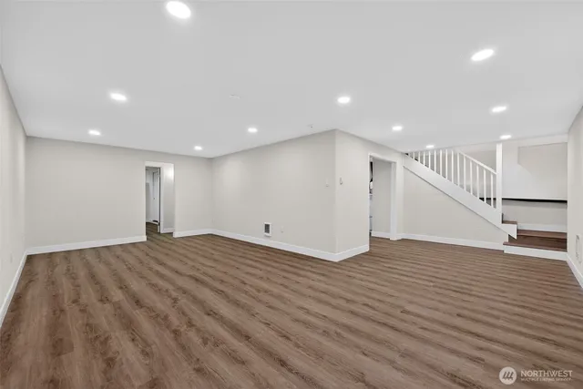 a view of empty room with wooden floor