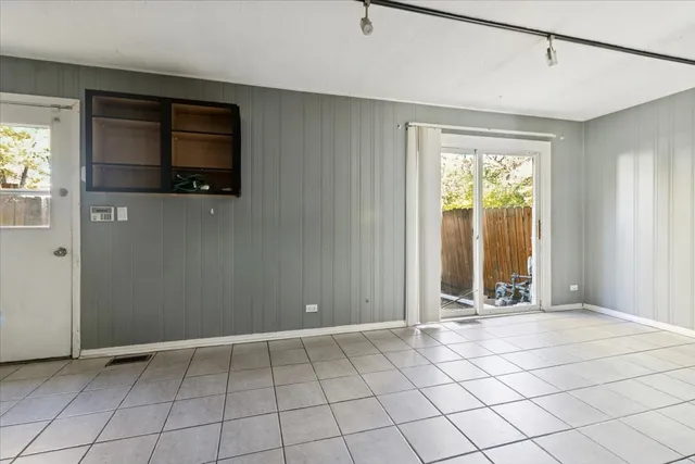 a view of an empty room with window and cabinet area