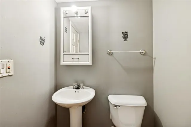 a bathroom with a sink a mirror and toilet