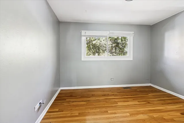 a view of a room with wooden floor and windows