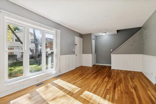 a view of a bedroom with wooden floor and windows