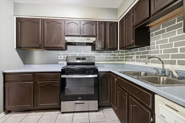 a kitchen with stainless steel appliances granite countertop a sink stove and cabinets